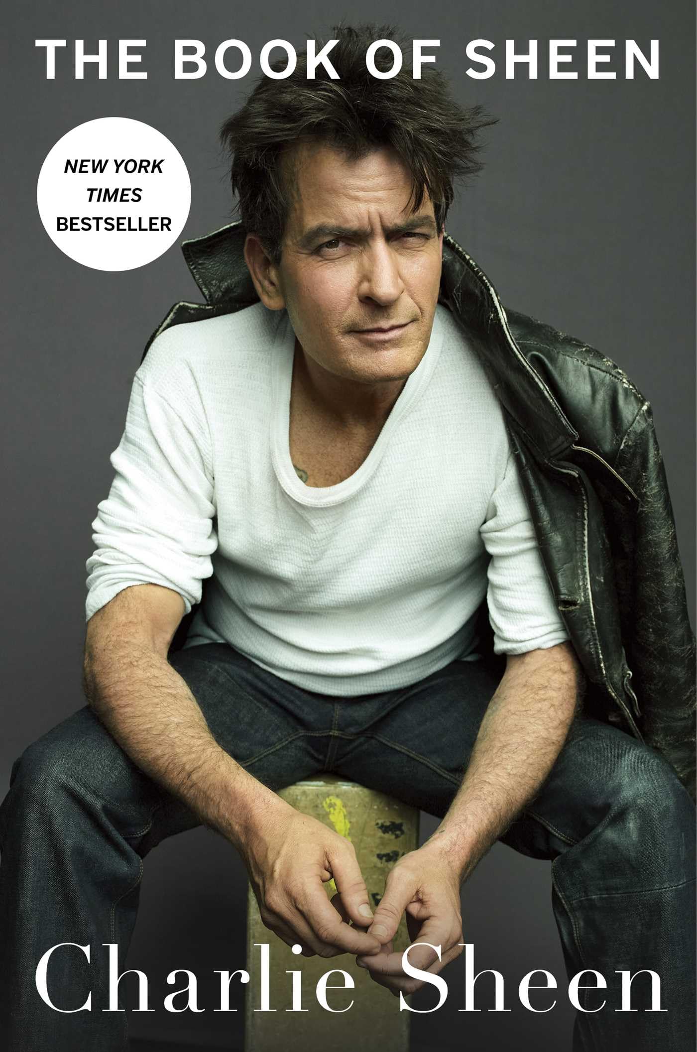Version 100 – To Speak Online Book cover featuring Charlie Sheen in a white shirt and leather jacket, with the title 'The Book of Sheen' and a 'New York Times Bestseller' badge.
