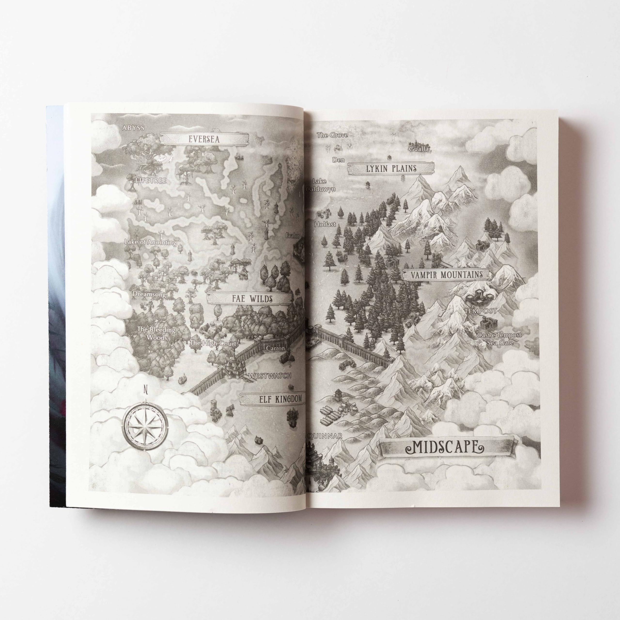Version 100 – To Speak Online Two-page spread in a book showing a grayscale fantasy map with labeled regions like Lykin Plains, Midscape, and snowy mountains.
