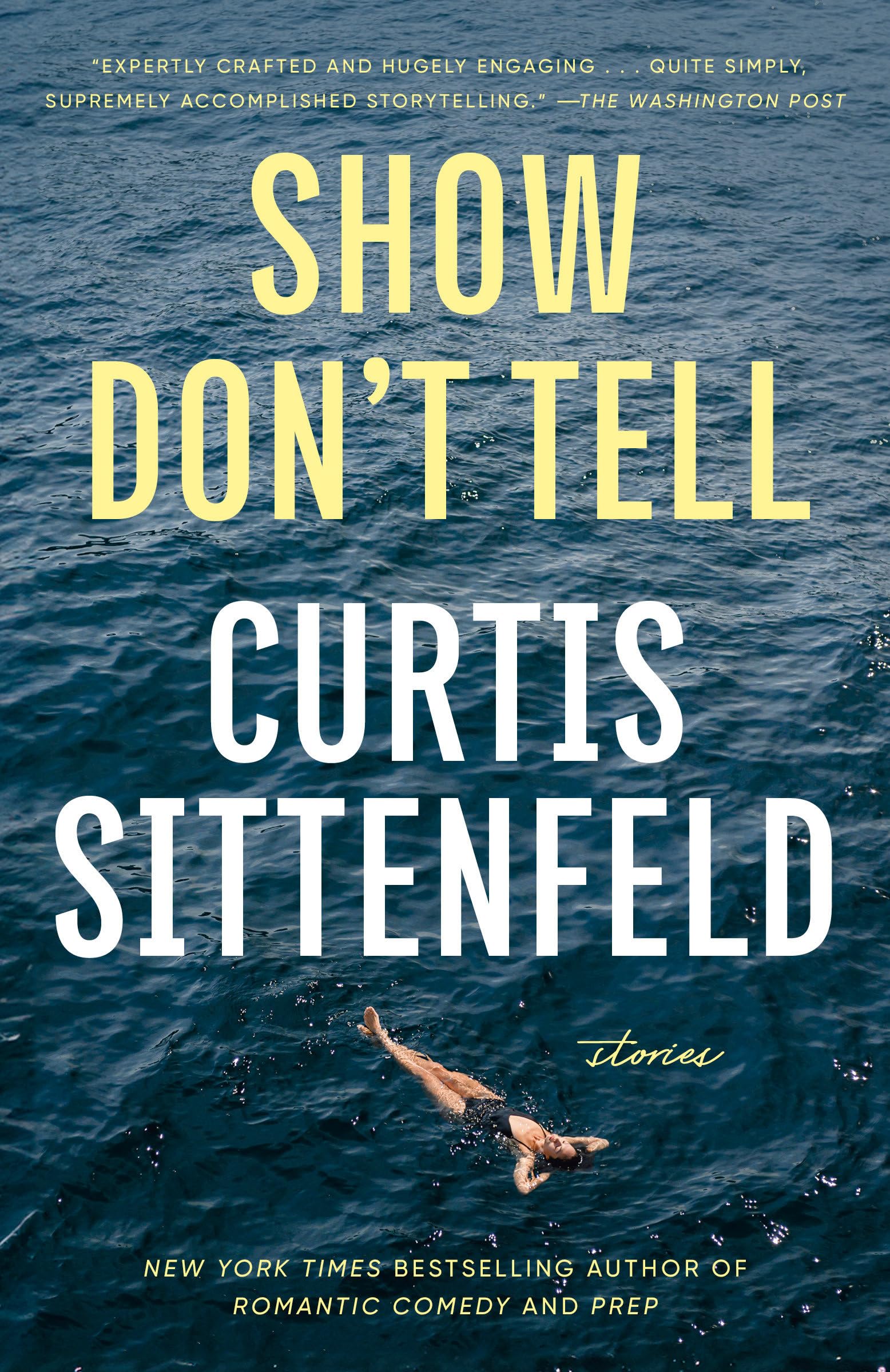 Version 100 – To Speak Online Book cover with a blue ocean background, bold yellow title 'SHOW DON’T TELL' and white author name 'CURTIS SITTENFELD' overlaid, with a small script word 'stories' near the bottom.